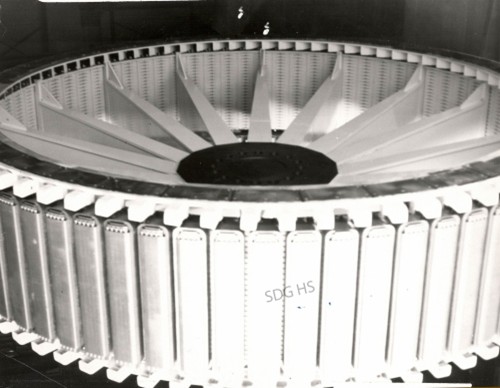 A large, circular machine component with evenly spaced vertical fins and radial blades, conveying a sense of industrial precision and engineering.